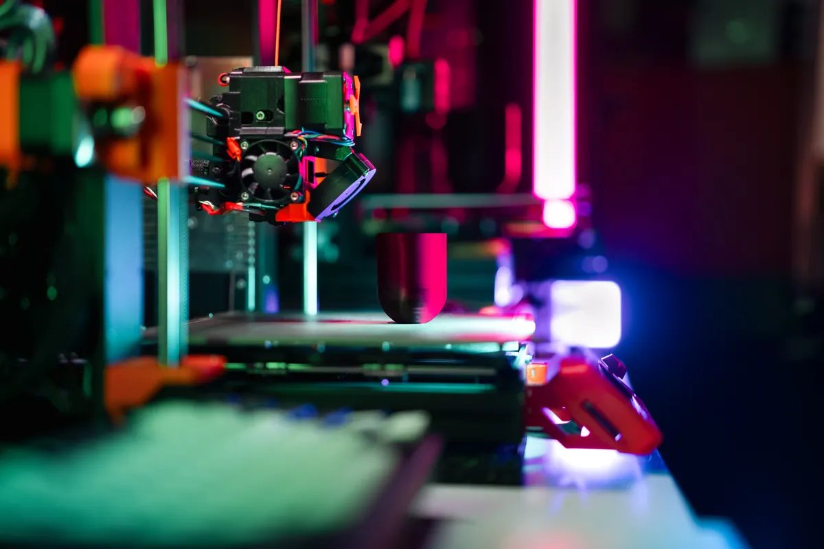 3D-Drucker in Neonlicht – KI im 3D-Druck